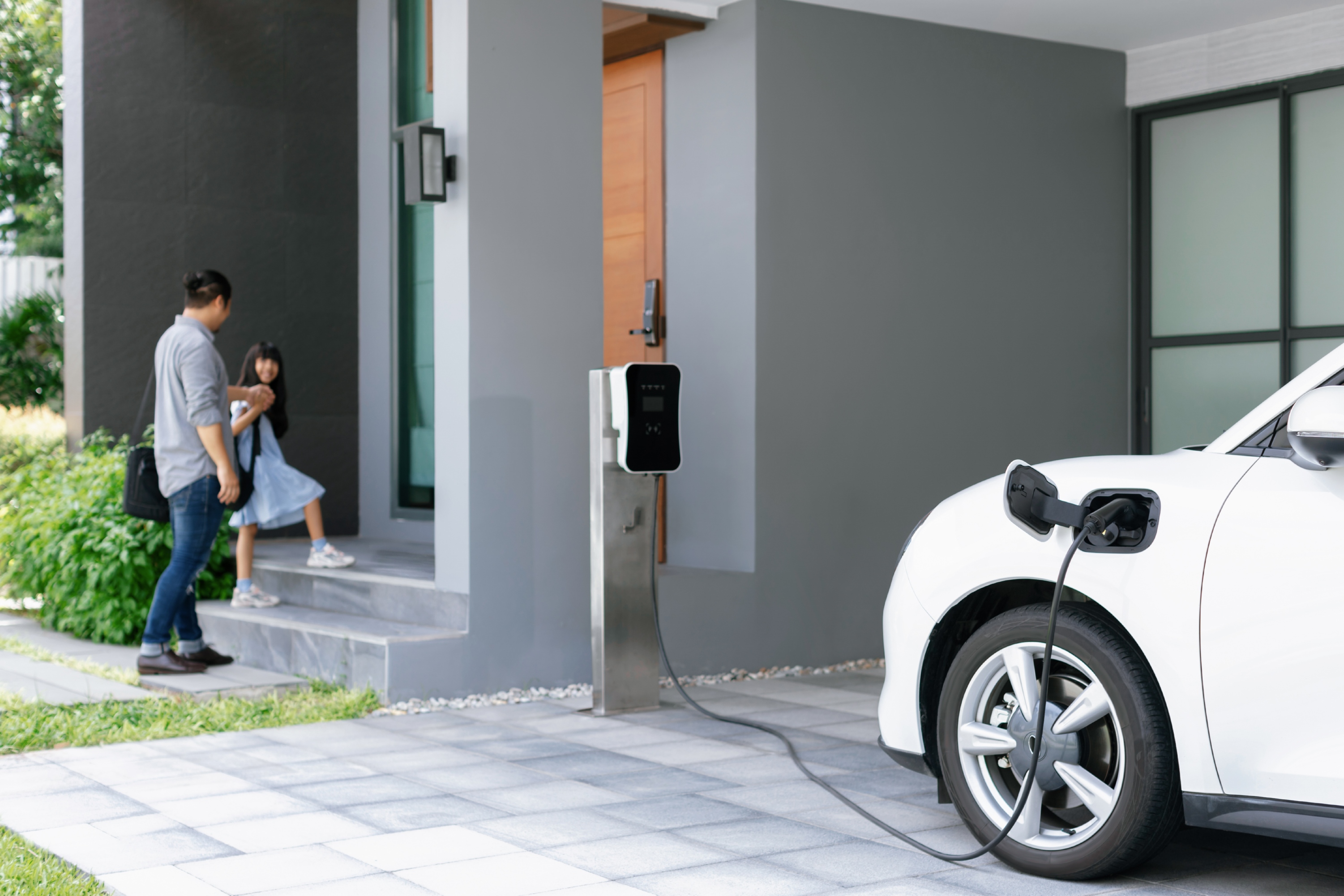 focus-progressive-ev-car-home-with-blur-father-his-daughter-background