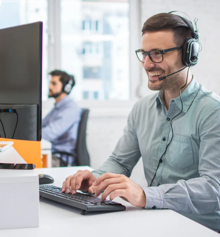 Energia+ Pomoc IT. Konsultant ze słuchawkami zdalnie pomaga klientom