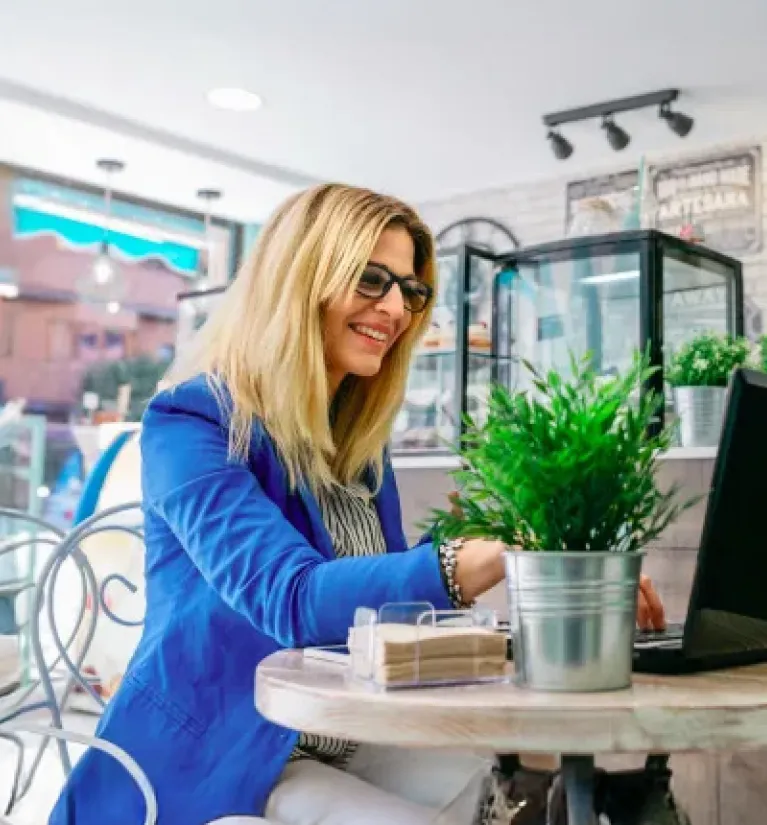 Przedsiębiorczyni pracująca przy laptopie w kawiarni